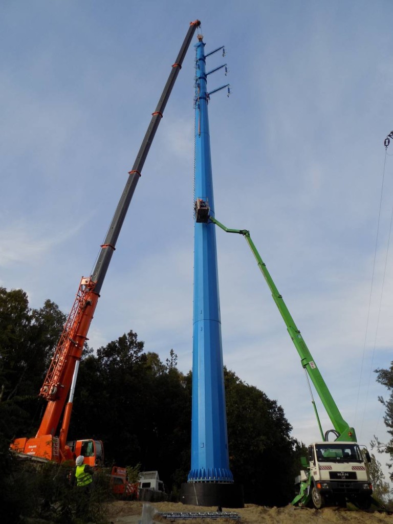 Żuraw samojezdny Demag AC120-1 o udźwigu 140 ton podczas montażu słupów energetycznych.
