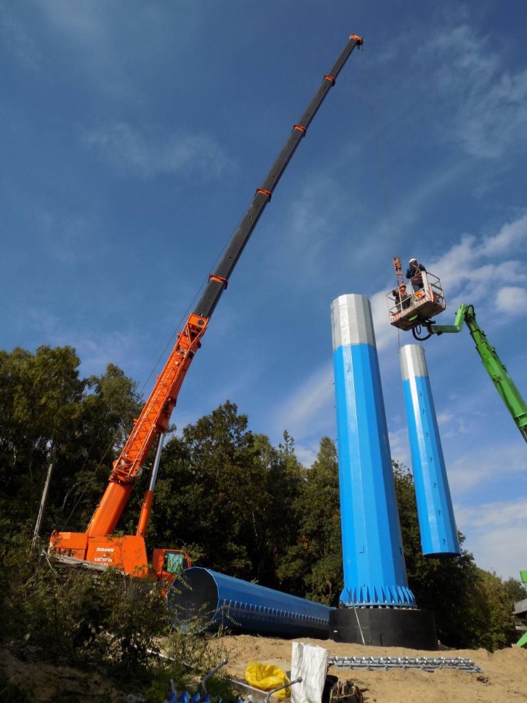 Żuraw samojezdny Demag AC120-1 o udźwigu 140 ton podczas montażu słupów energetycznych.