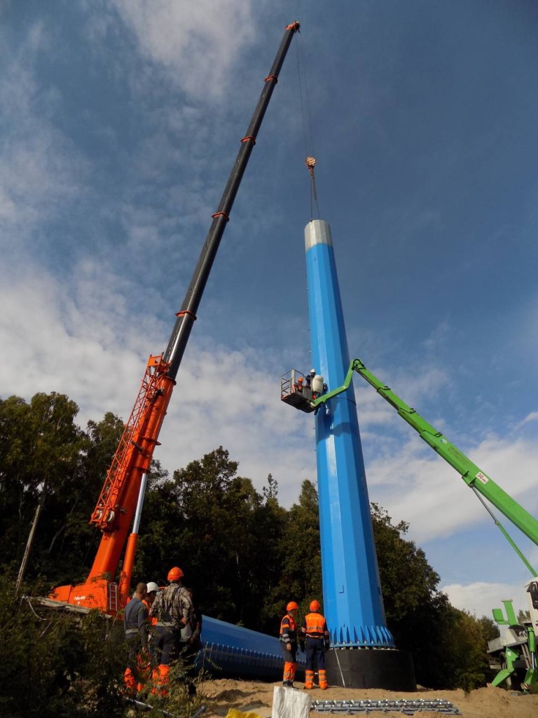Żuraw samojezdny Demag AC120-1 o udźwigu 140 ton podczas montażu słupów energetycznych.